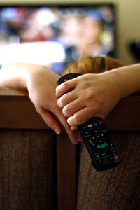 Woman holding remote while watching tv