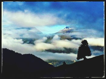 Scenic view of mountains against cloudy sky