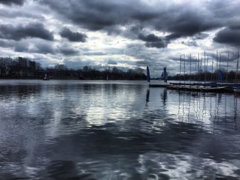 City at waterfront against cloudy sky