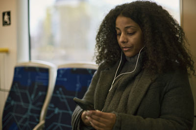 Woman in train using cell phone