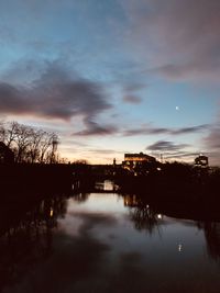 Silhouette trees by lake against sky during sunset