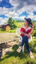 Side view of woman sitting on field