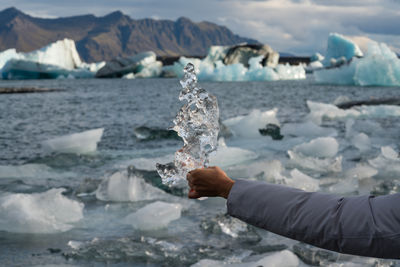 Female hand pointing out towards jökulsárlón glacier lagoon in iceland