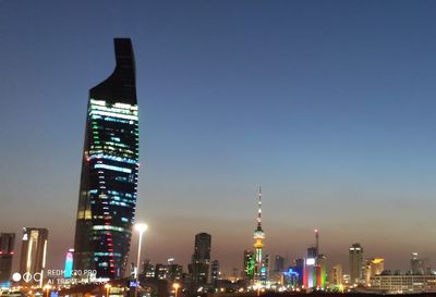Illuminated buildings in city against sky at night
