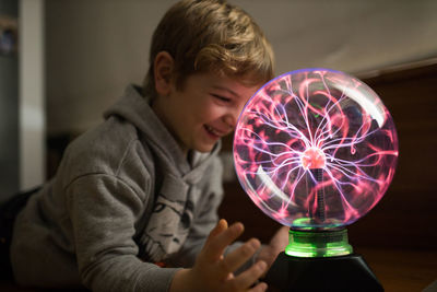 Portrait of boy holding illuminated lighting equipment