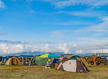 Multi colored tent on field against sky