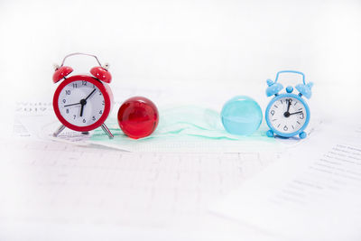 Close-up of clock on table against white background