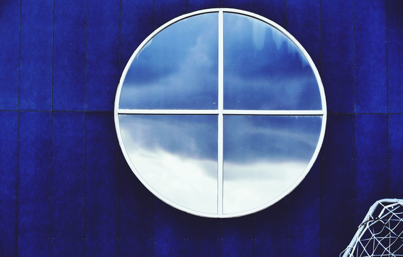circle, architecture, built structure, geometric shape, sky, low angle view, blue, reflection, building exterior, shape, indoors, cloud - sky, modern, glass - material, no people, window, round, pattern, cloud