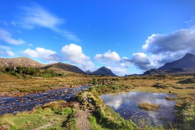 Scenic view of lake and mountains against blue sky