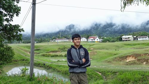 Portrait of young man standing on field