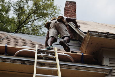 Low angle view of man jumping against built structure