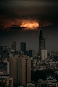 Modern buildings in city against sky during sunset