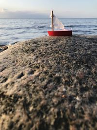 Boat on shore at beach against sky