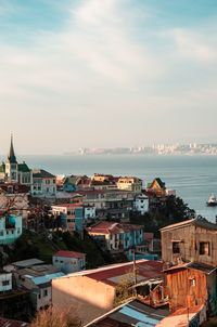 High angle view of townscape by sea against sky