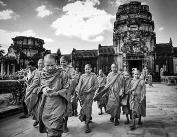 People at temple against sky in city