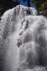 Water spraying against sky