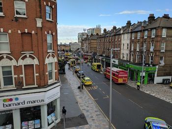 Vehicles on road against buildings in city