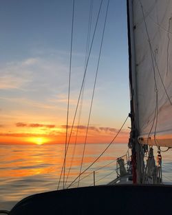 Silhouette sailboat on sea against sky during sunset