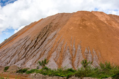 A large pile of sand was piled up in the sun and rain for many years.