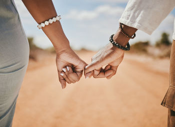 Midsection of couple holding hands