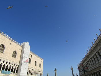 Low angle view of buildings against clear blue sky