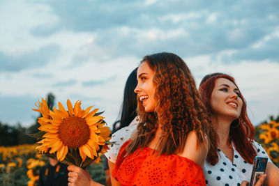 Beautiful young woman against white flowering plants against sky