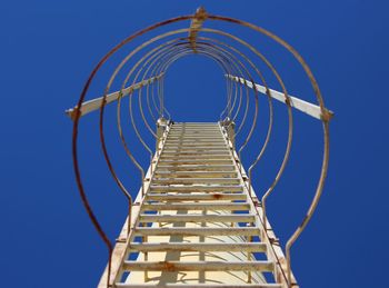 Low angle view of ladder against clear blue sky