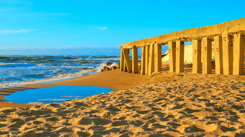 Scenic view of beach against clear blue sky