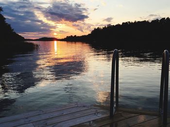 Pier on lake at sunset