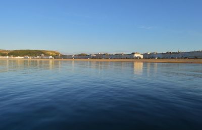 Calm sea against clear blue sky