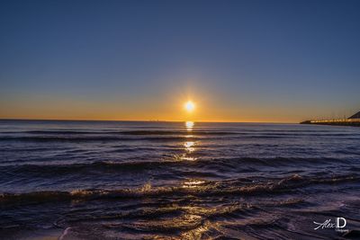 Scenic view of sea against clear sky during sunset