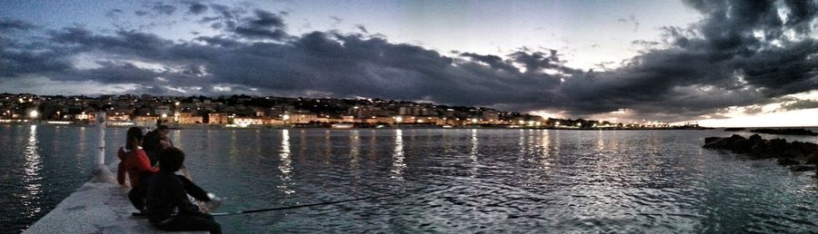 River in city against cloudy sky