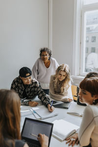 Teacher standing behind students in classroom