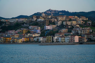 Town by sea against clear sky