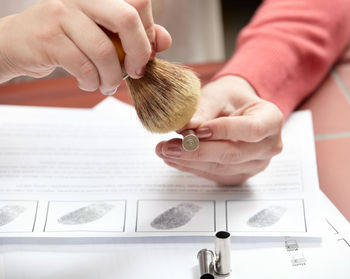 Cropped hand of woman applying make-up