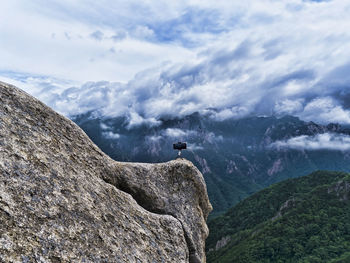 Scenic view of mountain range against sky and making photo by a phone