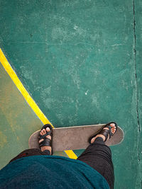 Low section of man standing against yellow wall