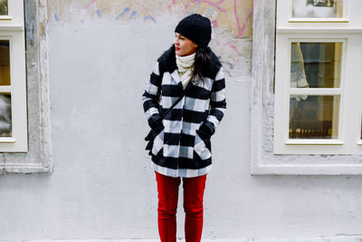 Full length of woman standing against building