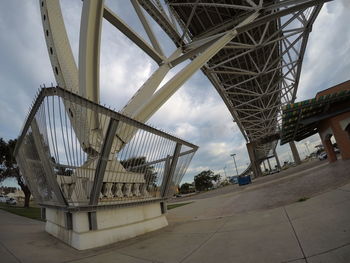 Low angle view of bridge against cloudy sky