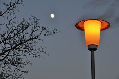 Low angle view of illuminated street light against sky