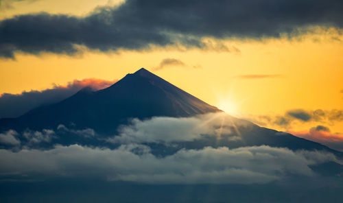 Scenic view of snowcapped mountains against sky during sunset