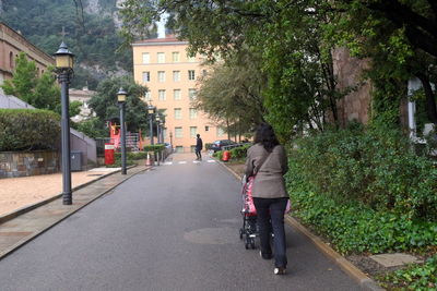 Rear view of person riding bicycle on road