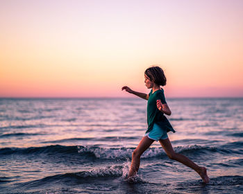 Full length of man standing on beach during sunset