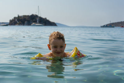 Portrait of shirtless boy swimming in water