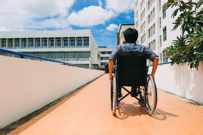 Rear view of man sitting against sky