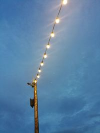 Low angle view of illuminated street light against sky