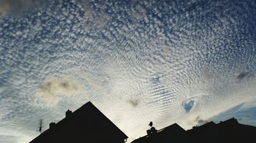 Low angle view of silhouette building against sky