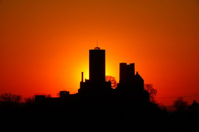 Silhouette of buildings against orange sky