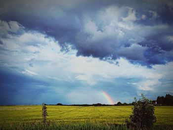 Scenic view of field against cloudy sky