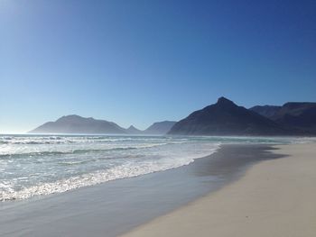 Scenic view of beach against clear blue sky